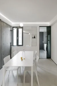 Modern minimalist kitchen with white cabinets and white countertops.