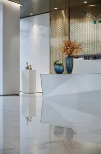 A modern office space with a marble reception counter and decorative vases.