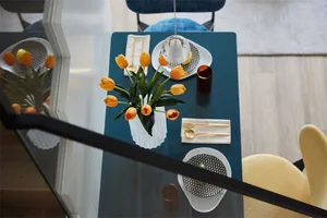 Modern table setting featuring ceramic flowers and a glass vase.