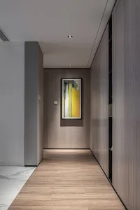 A modern interior corridor featuring wooden flooring and a framed abstract painting on the wall.