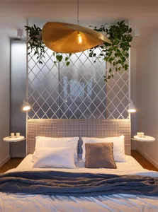 Minimalist bedroom with a modern design featuring textile bedding, wood headboard, and glass partition.