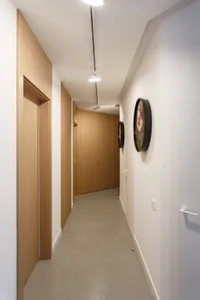 Modern corridor featuring wooden walls and concrete flooring.