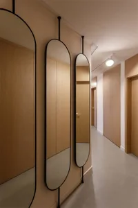 Modern minimalist interior with wooden cabinets and hanging mirrors.