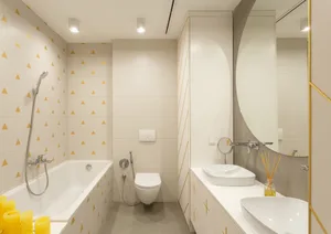 Modern minimalist bathroom interior with tiled walls and floor, featuring a bathtub, toilet, and dual sinks