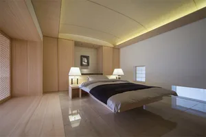 A modern bedroom featuring wooden flooring and minimalist design elements.