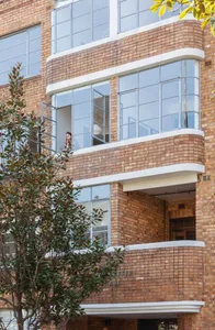 A modern building with a brick exterior features large windows.