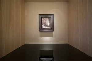 Modern interior design featuring a photograph of a minimalist space with wooden walls and a black table.