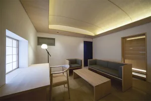 A modern living room with wooden furniture, featuring a sofa, table, and lamp