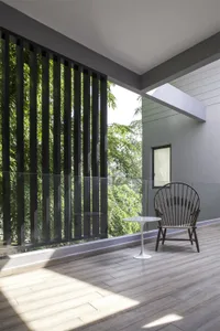 Industrial-style balcony featuring wooden slats and a chair with a small table.