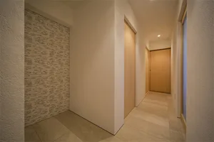 A minimalist house hallway with wooden walls and doors.