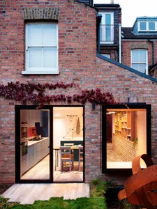 Modern kitchen extension with brick walls and large windows.