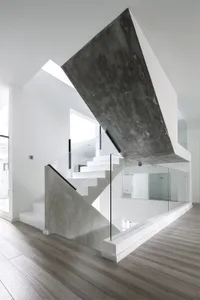A modern interior design space featuring concrete and glass materials.