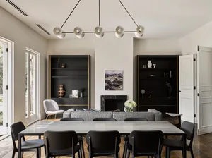A modern living room featuring concrete decor and minimalist furniture, with large windows and a fireplace.