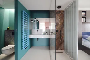 A modern minimalist bathroom with marble accents and a white floor.