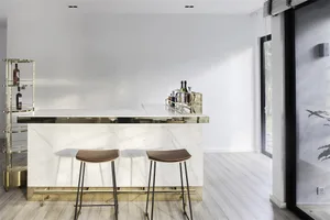 Minimalist design with white marble top and bar stools.