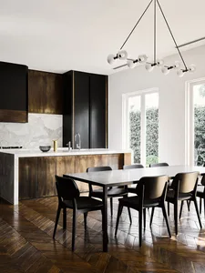 A modern residential kitchen featuring marble countertops, metal cabinets, and wooden flooring.