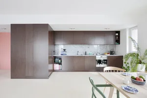 A contemporary kitchen with dark wood cabinets and a marble countertop.