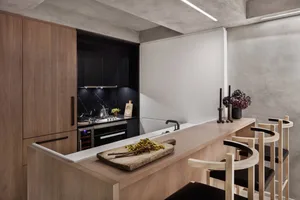 A modern kitchen with wooden cabinets and a wooden counter, featuring a minimalist design.