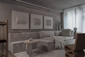 Modern living room featuring concrete walls and upholstered seating