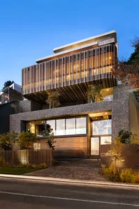 A modern residential building with concrete, wood, and glass elements.