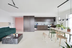 A modern residential kitchen featuring a composite stone counter and dining table with chairs.