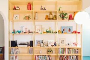 A modern interior with wooden bookshelves displaying books and decorative items.