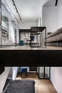 Modern, minimalist residential interior with metal, glass, wood, and textile finishes.