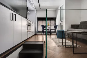 Modern minimalist kitchen with wood flooring and furniture.