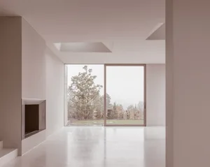 Modern minimalist living room featuring concrete and glass materials with large windows.