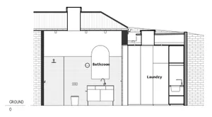 Modern bathroom and laundry room with white concrete walls, black accents, and exposed brick walls