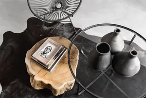 A stylish modern coffee table setting with wooden, ceramic, and metallic elements.
