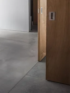 A wooden door with a concrete floor, showing a minimalist and modern aesthetic.