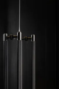 Close-up of modern lighting fixtures with a textured metal surface against a dark background.