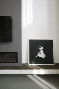 A modern minimalist interior with a framed black and white photograph of a dancer.