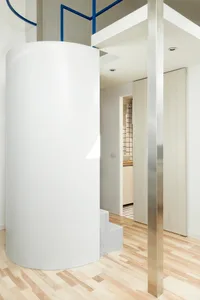 Interior design featuring modern minimalist elements like concrete surfaces and stainless steel features.