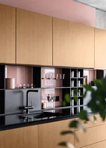 Modern minimalist kitchen with wooden cabinets and black countertops.
