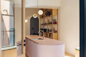 A minimalist kitchen with a terrazzo countertop and a large window.