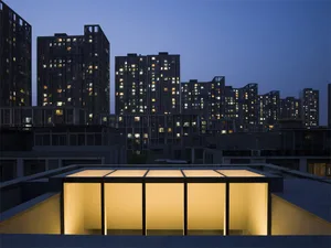 A modern cityscape with illuminated buildings at dusk.