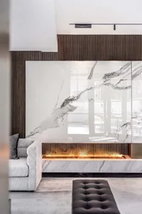A modern living room with marble fireplace and wooden accents.