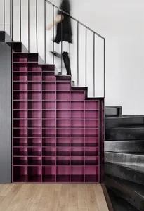 A modern staircase with built-in metal shelving units.