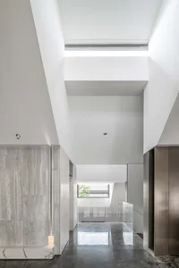 Modern residential entrance featuring concrete, glass, and marble materials.