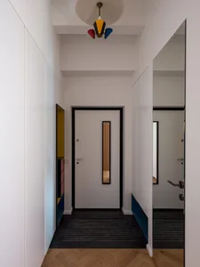 A minimalist interior with white walls, wooden flooring, and metallic accents.