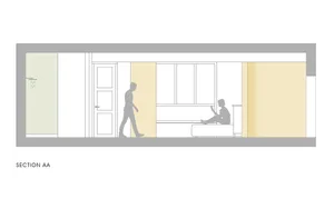 Minimalist bedroom section with a person sitting on a bed and another walking by, featuring light-colored walls and a bed wit