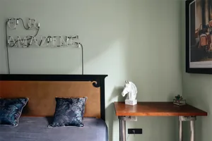 A modern bedroom featuring a concrete headboard and minimalist decor.