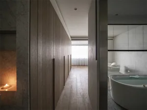 Minimalist bathroom with wood-paneled walls and marble finishes.