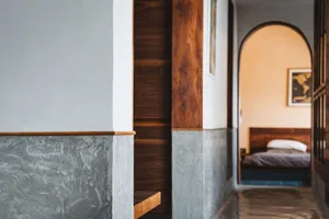 A minimalist bedroom with concrete, wood, and metal elements.