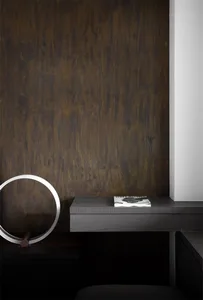 A minimalist desk space featuring a black wooden floating desk with a metallic circular light fixture and a book.