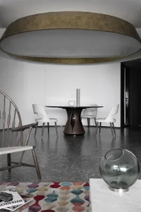 A modern dining room featuring a marble table and wooden chairs.