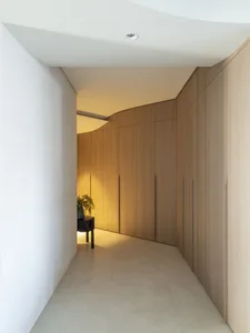 Modern minimalist closet with wooden cabinets and clean lines.