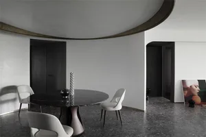 Modern minimalist dining room with a round marble table and white chairs